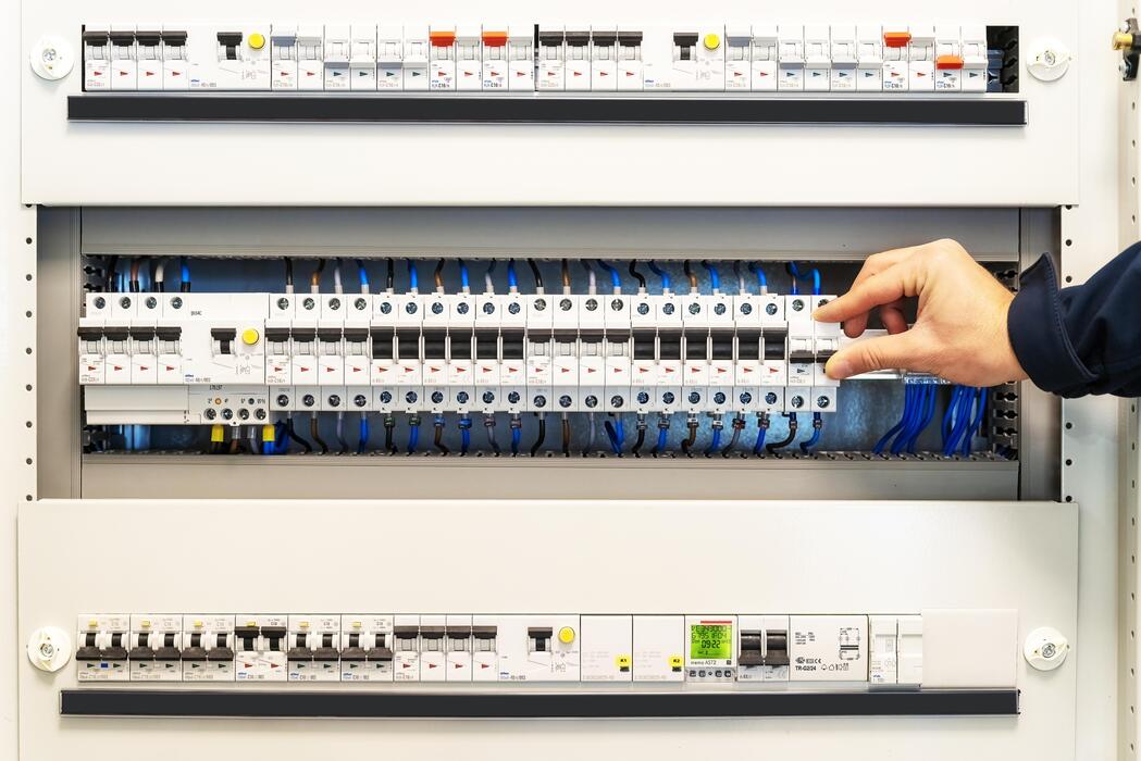 close-up-of-the-hand-of-a-male-electrician-on-a-switchboard-photo